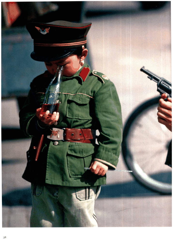 身穿仿制军装喝汽水的男孩