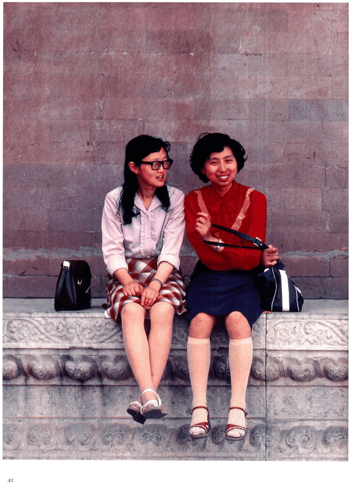 红墙下的两位年轻女性