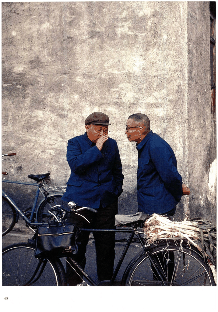 老照片：墙根下交谈的两位老人