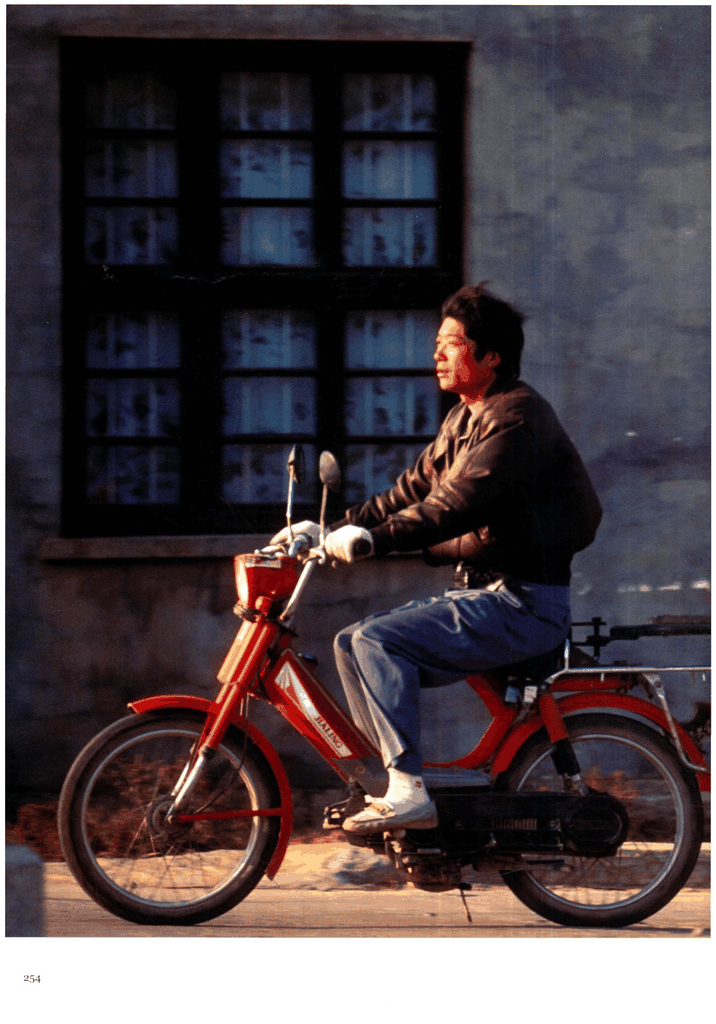 骑着红色轻骑摩托的青年