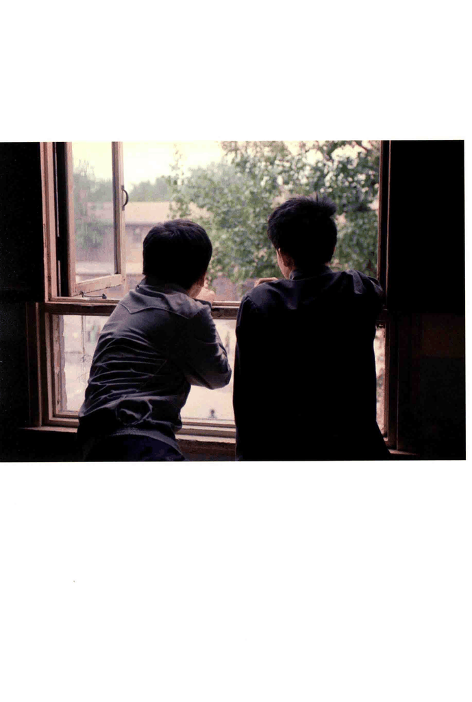 两个少年在窗边向外张望的背影