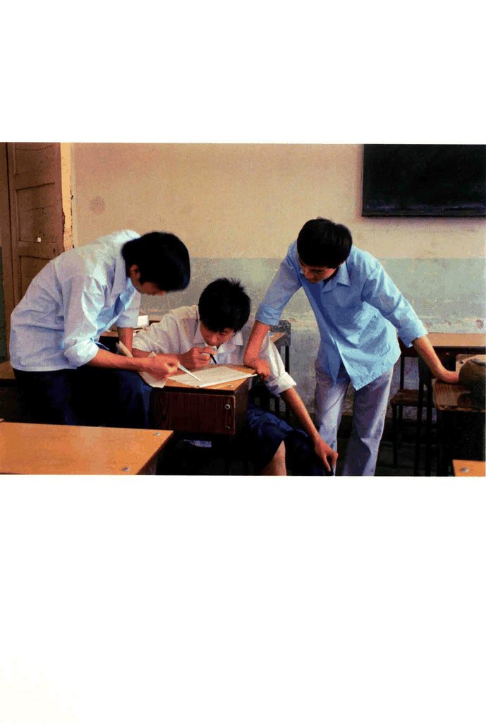 三个男生在课桌前讨论学习