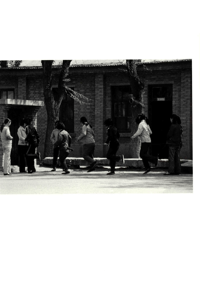 一群年轻女性在砖房前活动