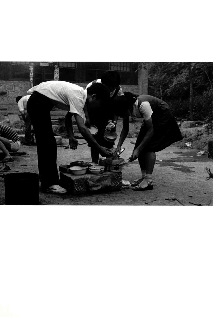 几个年轻人在简易水槽边洗碗